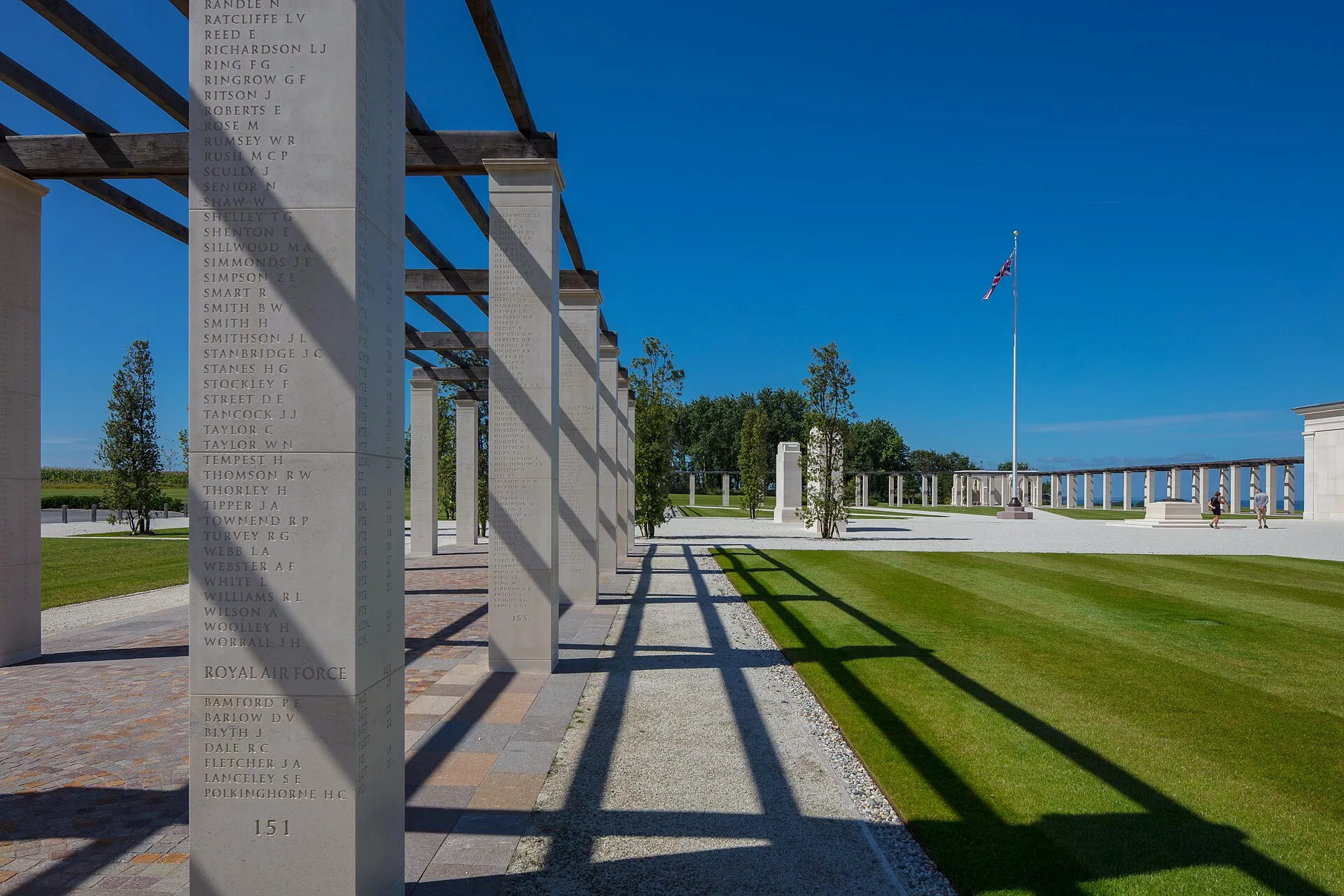 Colonnades de pierre gravées de noms de soldats britanniques et drapeau du Royaume-Uni au British Normandy Memorial de Ver-sur-Mer