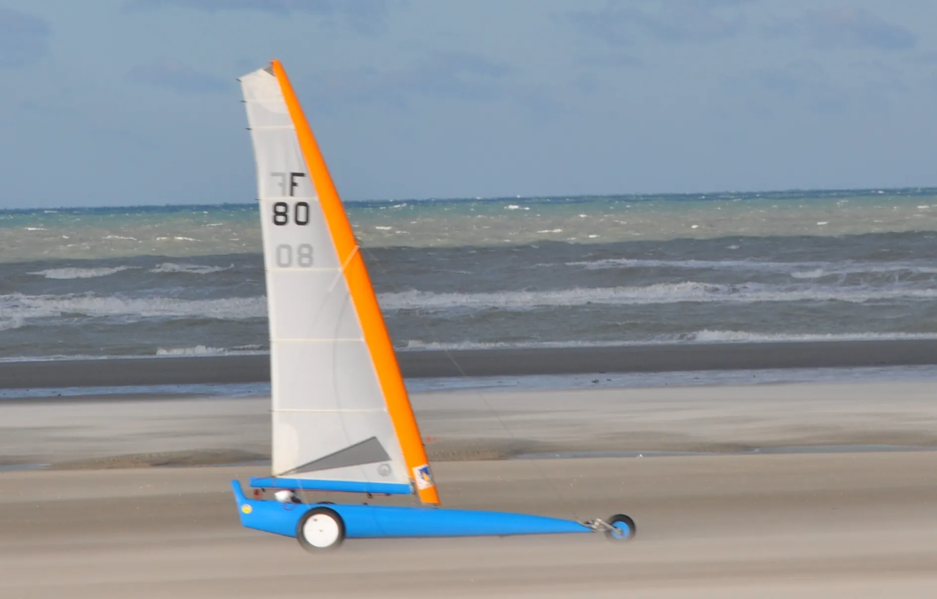 Char à voile de compétition roulant sur une plage de sable, illustration de l'activité