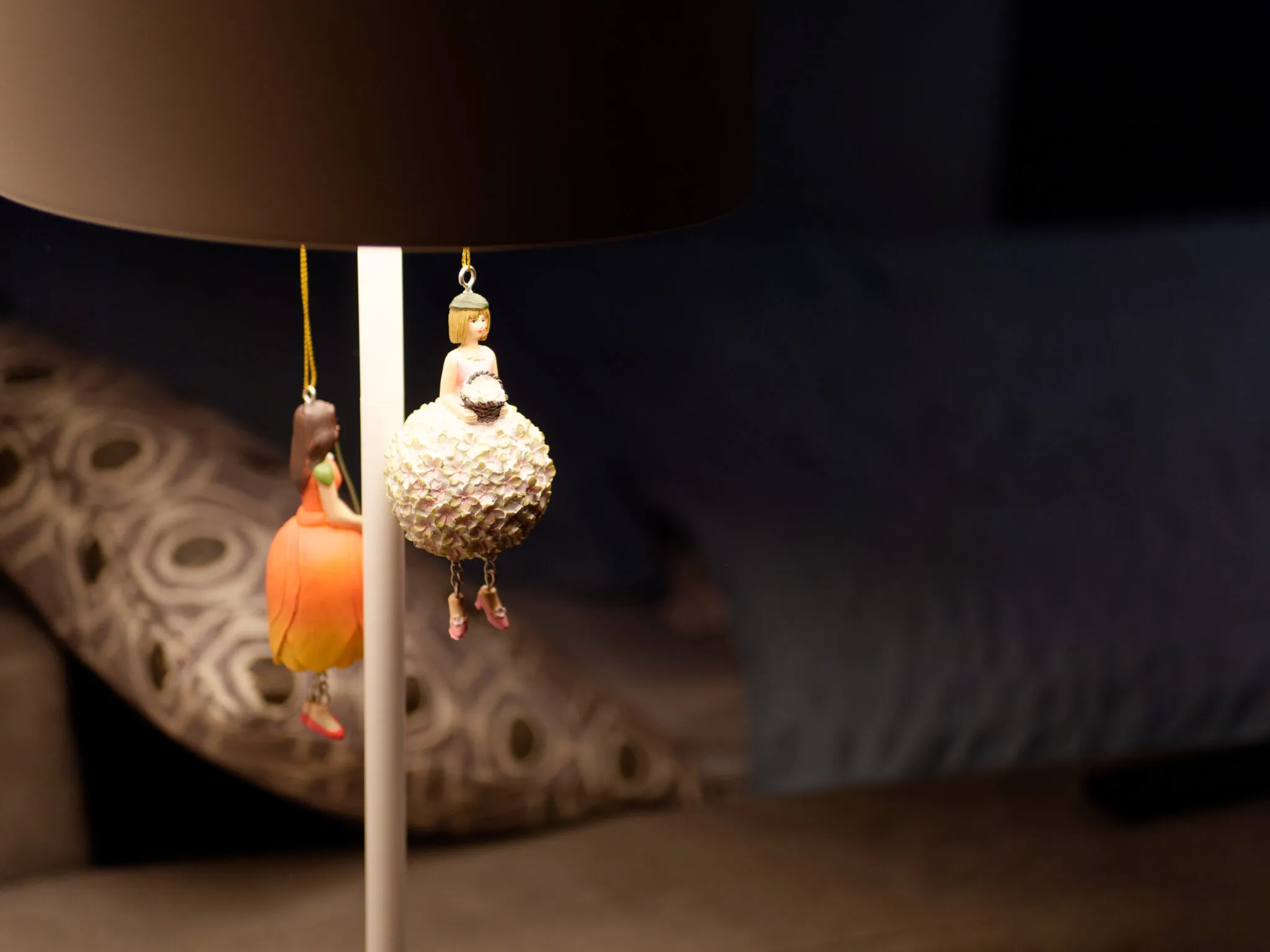 Détail de décoration du studio, figurines suspendues à une lampe dans une lumière tamisée