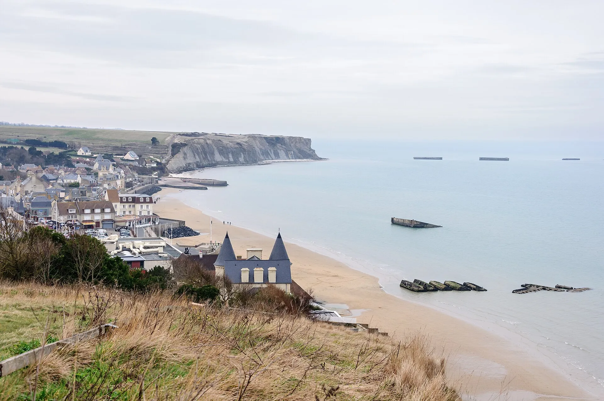 Le front de mer d'Arromanches-les-Bains et les vestiges du port artificiel Mulberry dans la baie