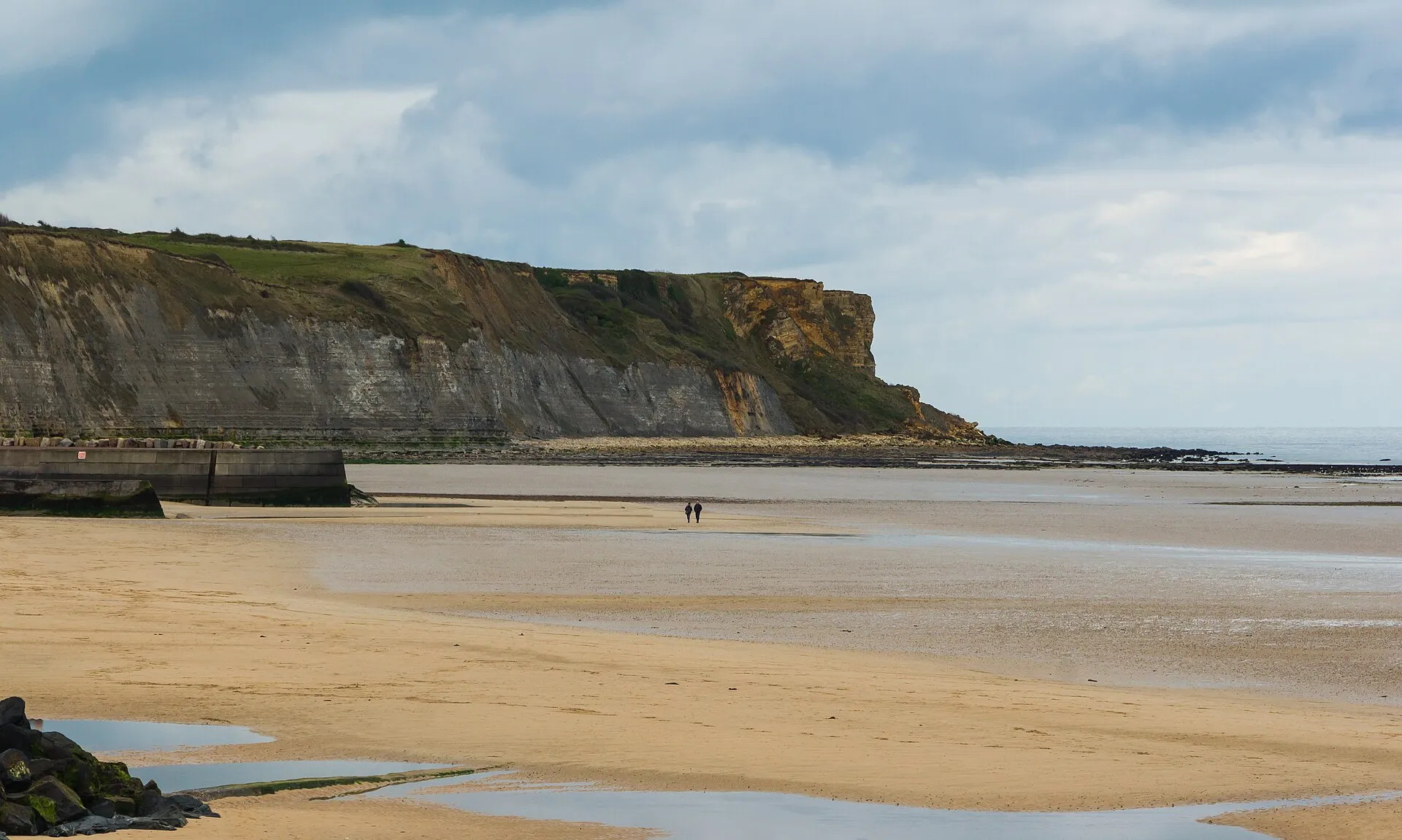 Vue de la plage de Gold Beach à Arromanches-les-Bains et de ses falaises sous un ciel dégagé